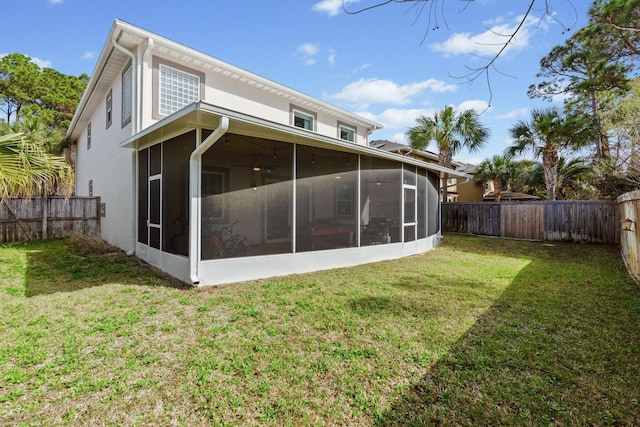 rear view of property with a sunroom and a lawn