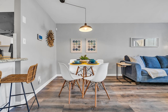 dining space featuring baseboards and wood finished floors