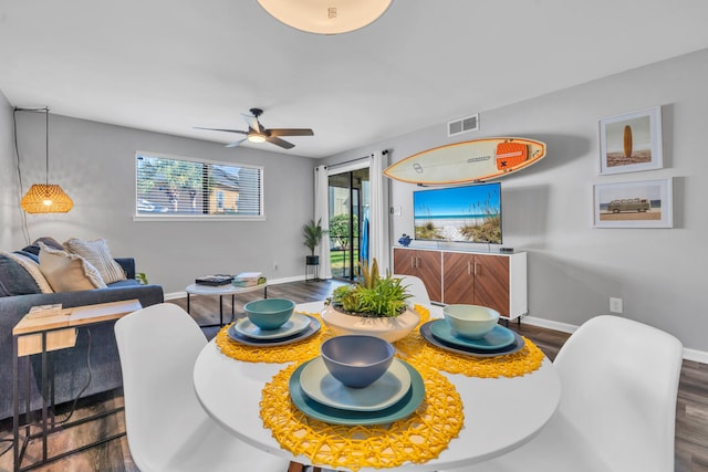 dining room featuring visible vents, baseboards, ceiling fan, and wood finished floors