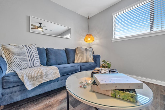 living area featuring wood finished floors, a ceiling fan, and baseboards