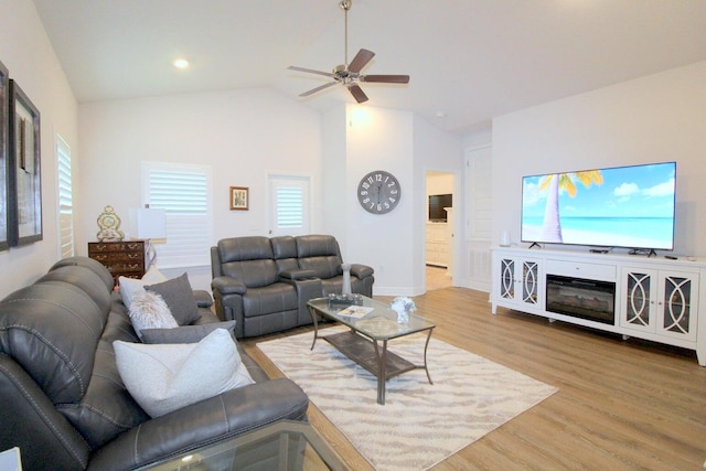 living room with vaulted ceiling, light hardwood / wood-style flooring, and ceiling fan