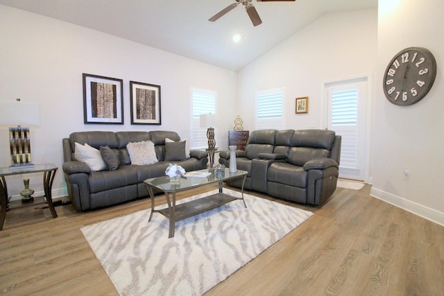 living room featuring light wood-type flooring, ceiling fan, high vaulted ceiling, and a healthy amount of sunlight