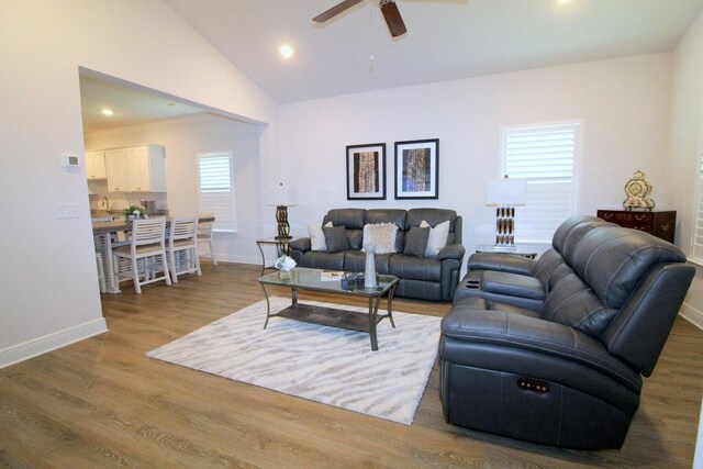 living room with vaulted ceiling, hardwood / wood-style flooring, sink, and ceiling fan