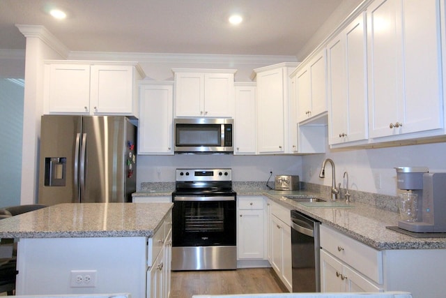 kitchen with light stone countertops, appliances with stainless steel finishes, light hardwood / wood-style floors, sink, and white cabinets