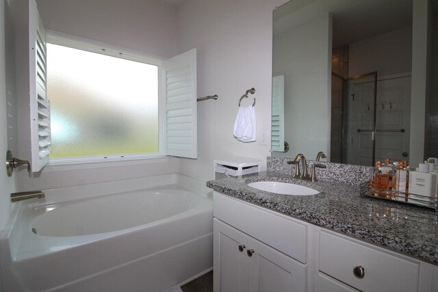 bathroom featuring vanity and a washtub