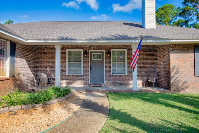 doorway to property with a yard and covered porch