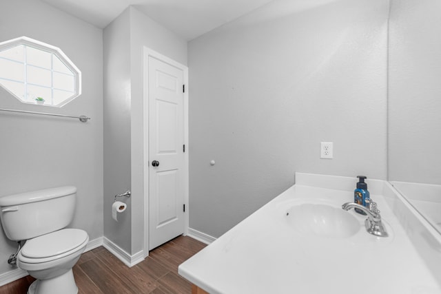 bathroom with hardwood / wood-style floors, vanity, and toilet