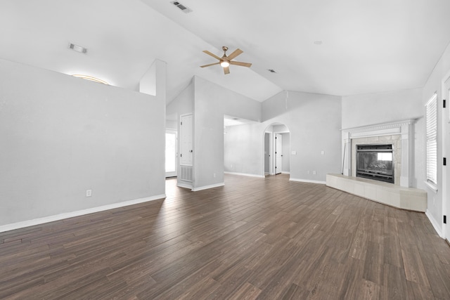 unfurnished living room featuring high vaulted ceiling, dark hardwood / wood-style floors, ceiling fan, and a tile fireplace