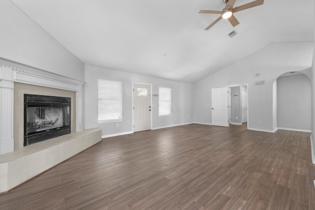 unfurnished living room featuring a tiled fireplace, high vaulted ceiling, dark hardwood / wood-style flooring, and ceiling fan