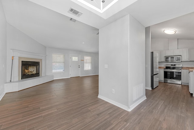 unfurnished living room featuring a fireplace, hardwood / wood-style flooring, and lofted ceiling