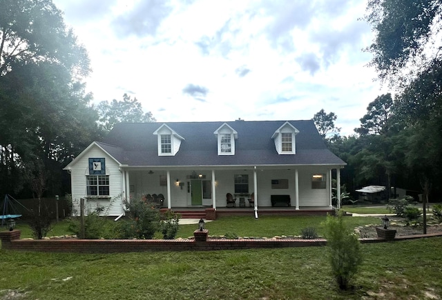 new england style home featuring covered porch and a front yard