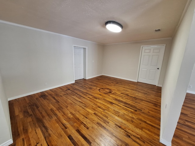 spare room featuring wood-type flooring and crown molding