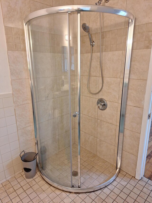 bathroom with tile patterned flooring and a shower with door