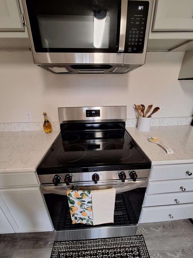 interior details with appliances with stainless steel finishes and light stone counters