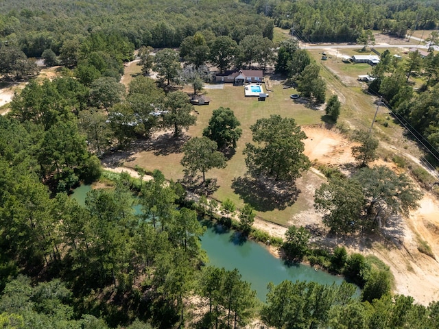 drone / aerial view with a water view and a forest view