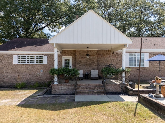 back of house with ceiling fan, a yard, a patio area, board and batten siding, and brick siding