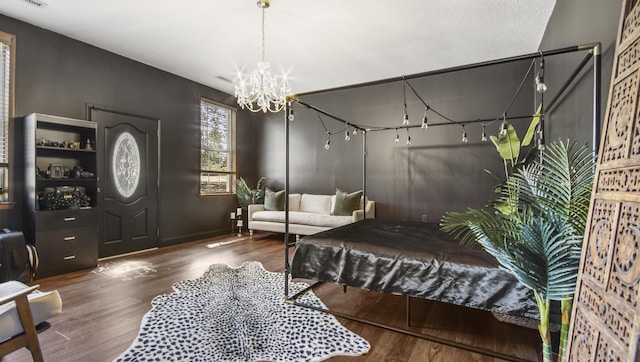 foyer entrance with visible vents, a chandelier, and wood finished floors