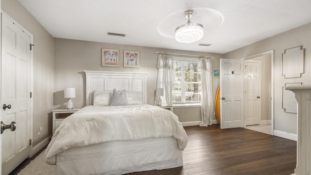 bedroom featuring visible vents, baseboards, and wood finished floors