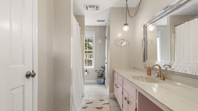 bathroom with visible vents, vanity, baseboards, and tile patterned floors