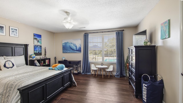 bedroom with dark wood finished floors, a textured ceiling, and baseboards