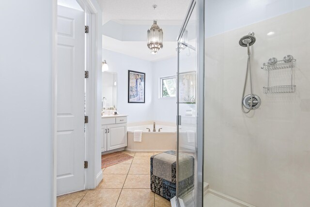 bathroom with plus walk in shower, tile patterned floors, an inviting chandelier, and vanity