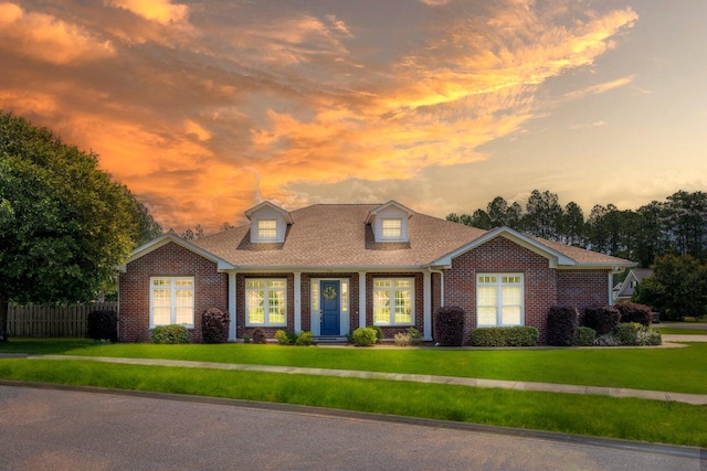 cape cod house featuring a lawn