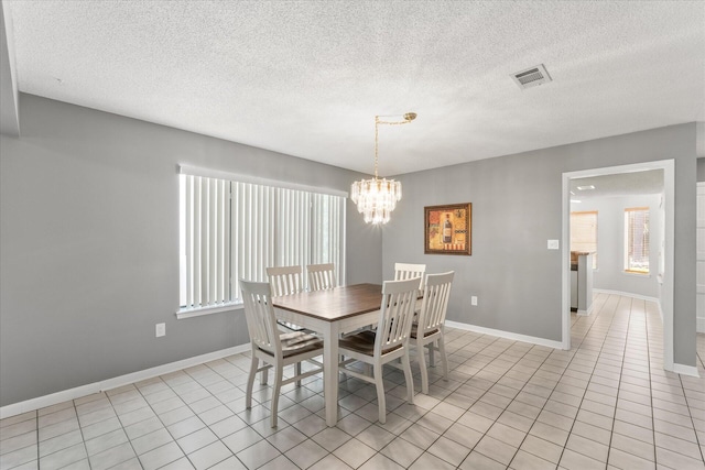 dining space with a textured ceiling, plenty of natural light, and a chandelier