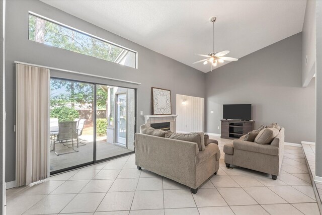 tiled living room featuring high vaulted ceiling, plenty of natural light, and ceiling fan