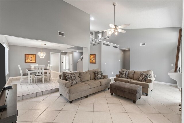 tiled living room with ceiling fan and high vaulted ceiling