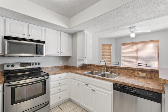 kitchen with ceiling fan, white cabinetry, stainless steel appliances, and sink