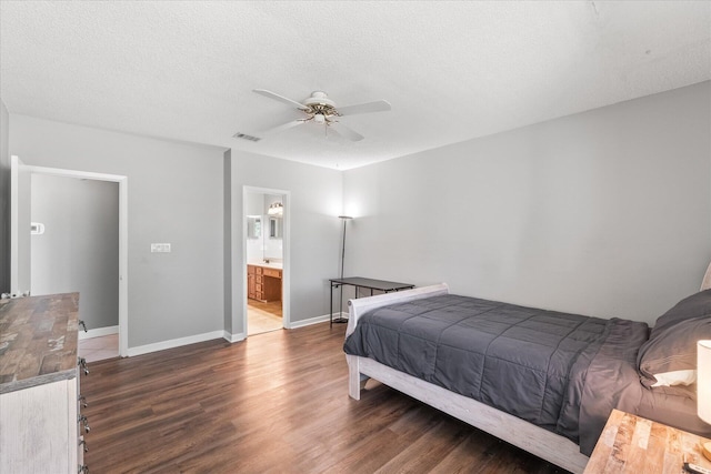 bedroom with ensuite bath, dark hardwood / wood-style flooring, ceiling fan, and a textured ceiling