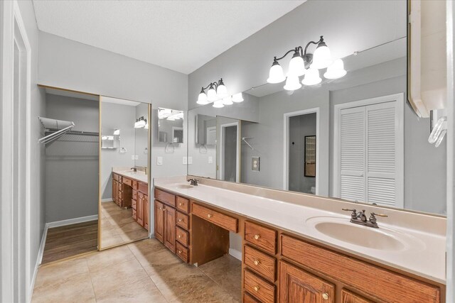 bathroom with tile patterned floors, a chandelier, and vanity