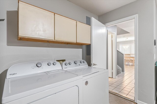 washroom with cabinets, washer and clothes dryer, and light tile patterned flooring