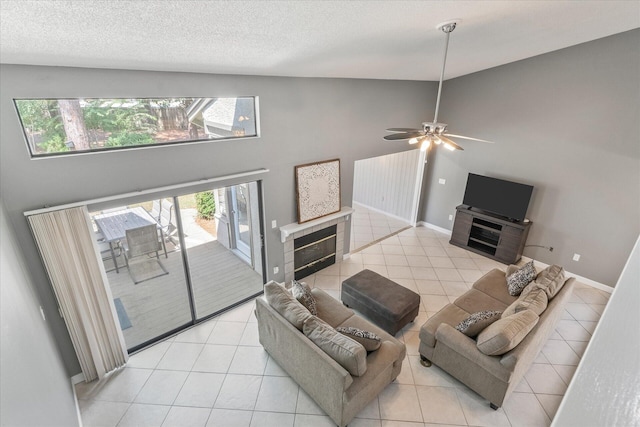 tiled living room featuring a healthy amount of sunlight, ceiling fan, high vaulted ceiling, and a tile fireplace