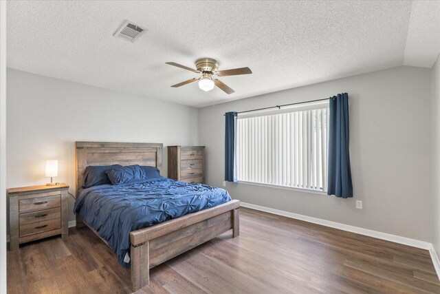 bedroom with lofted ceiling, a textured ceiling, ceiling fan, and dark hardwood / wood-style floors