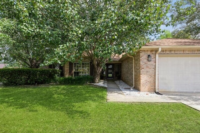 view of front of property with brick siding, an attached garage, and a front yard