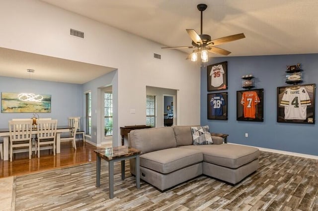 living room featuring high vaulted ceiling, ceiling fan, and hardwood / wood-style flooring