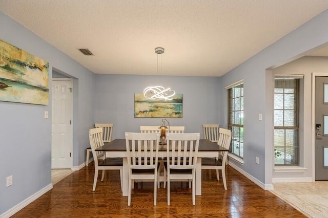 dining room with hardwood / wood-style floors and a textured ceiling