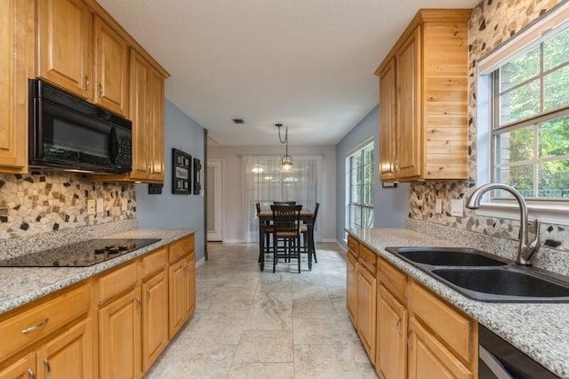 kitchen with plenty of natural light, black appliances, light tile patterned flooring, and tasteful backsplash