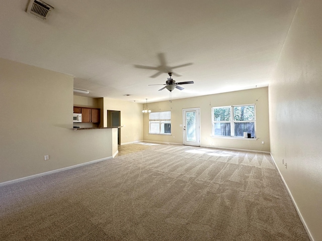 unfurnished living room featuring baseboards, a ceiling fan, visible vents, and light colored carpet