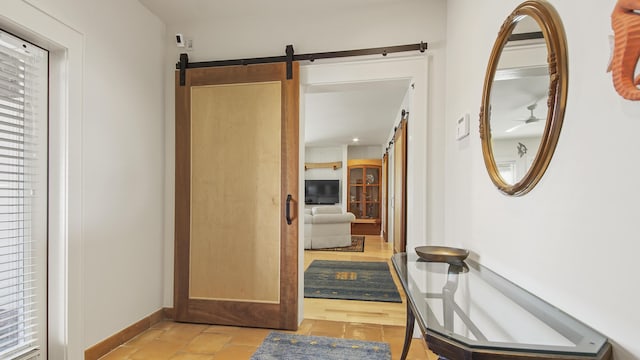 corridor with a barn door and baseboards