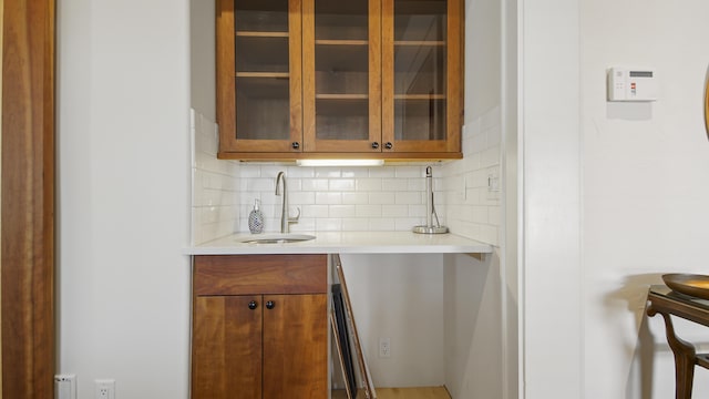 bar featuring backsplash and a sink