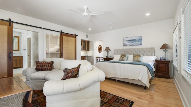 bedroom with ceiling fan, a barn door, light wood-style flooring, recessed lighting, and visible vents