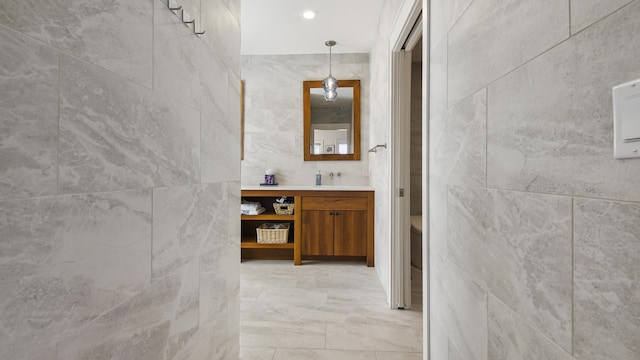 bathroom featuring toilet, vanity, and tile walls