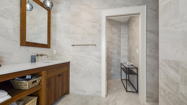 bathroom with vanity and tile walls