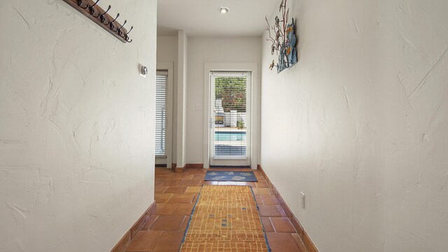 doorway featuring tile patterned flooring and baseboards