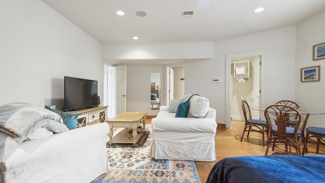 living area with light wood-type flooring, recessed lighting, visible vents, and baseboards