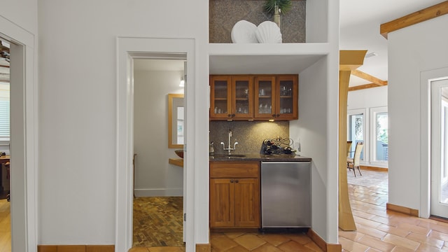 bar with tasteful backsplash, baseboards, a sink, fridge, and indoor wet bar