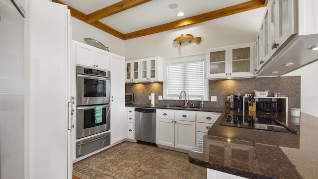 kitchen featuring beam ceiling, a warming drawer, stainless steel appliances, tasteful backsplash, and a sink