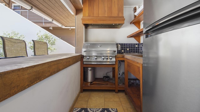 kitchen featuring light tile patterned floors, custom range hood, fridge, and open shelves